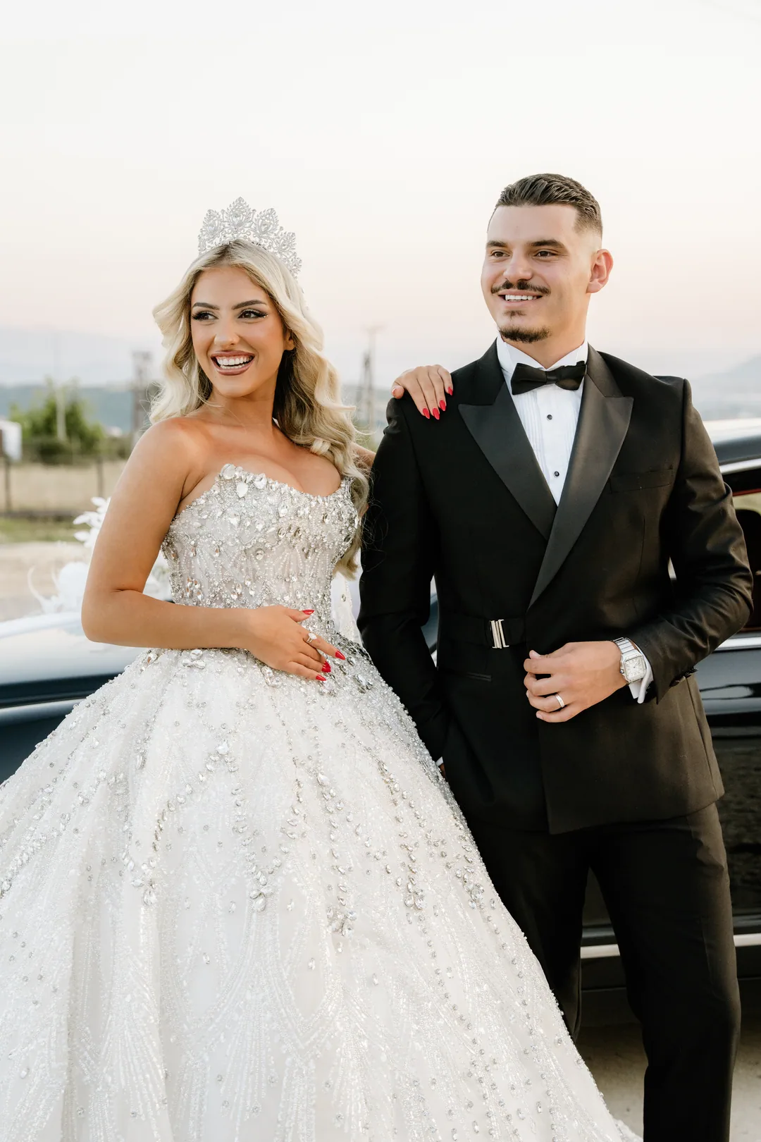Bride and groom laughing, her hand on his shoulder