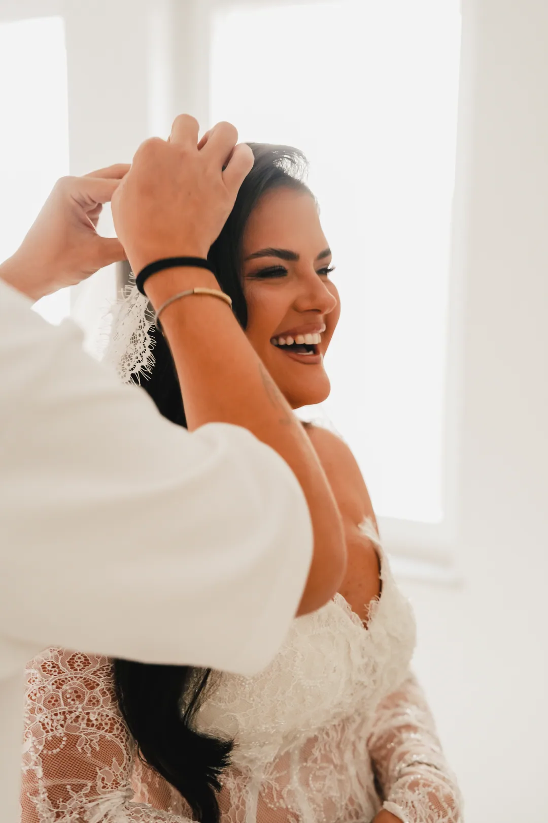 Bride laughing while her hair is being pinned up