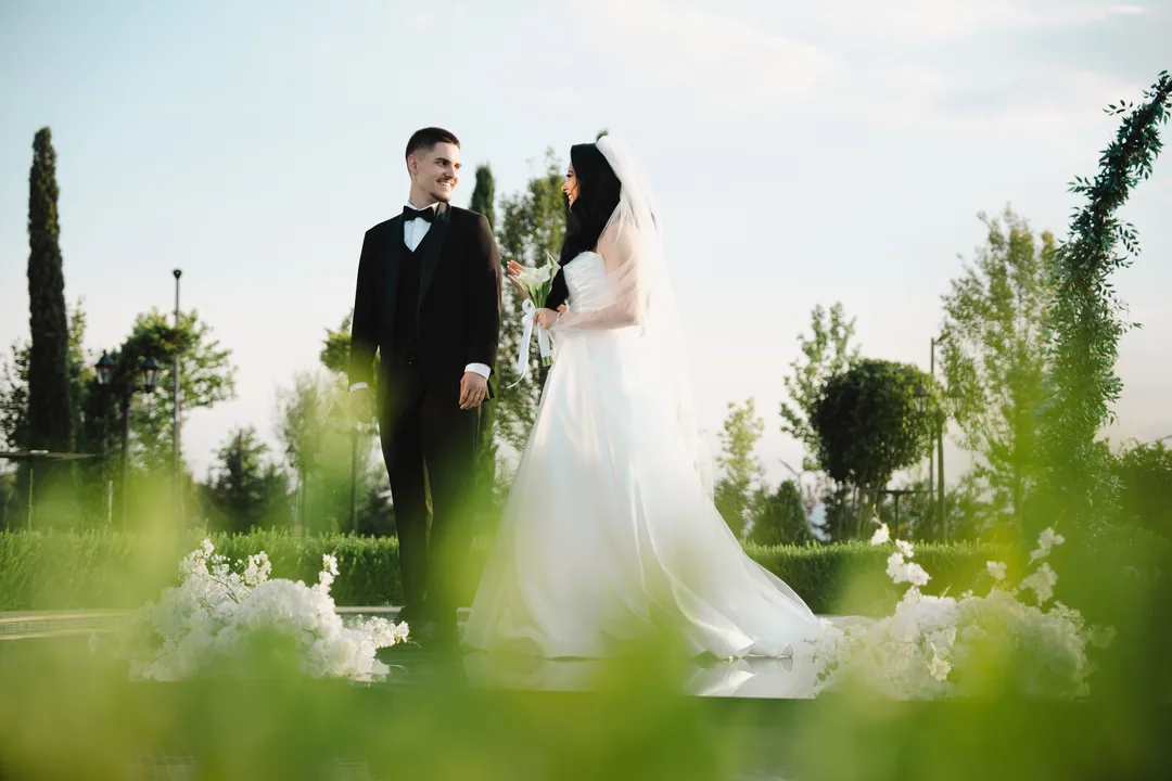 Couple in the garden, seen through soft green foliage and white flowers