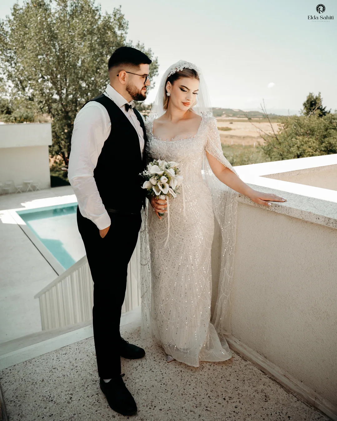 Couple on a terrace above the pool, fields stretching out beyond