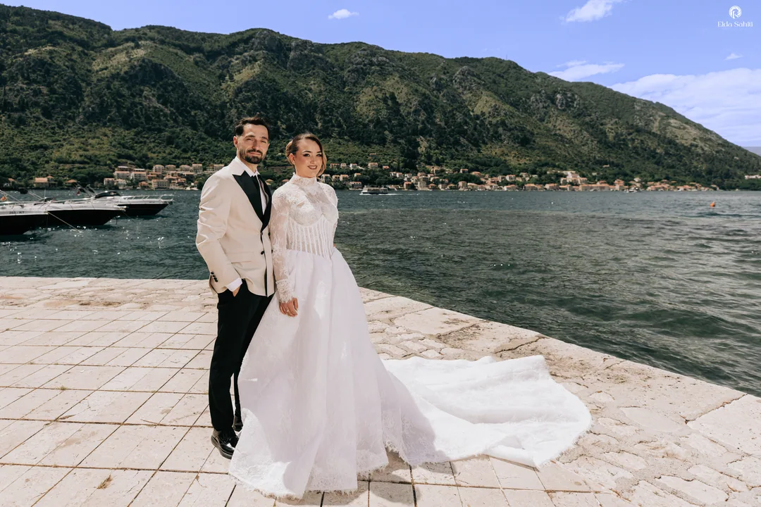 Bride and groom on the waterfront, the mountains rising across the bay