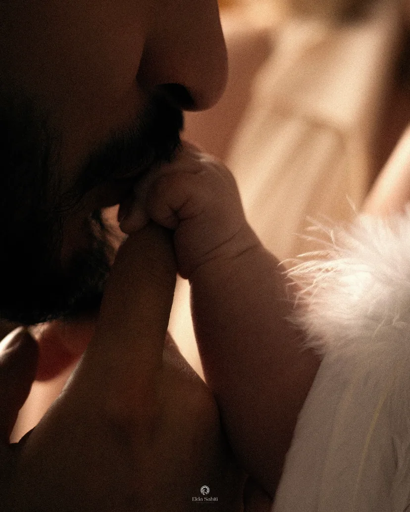 A father kissing his baby's tiny hand